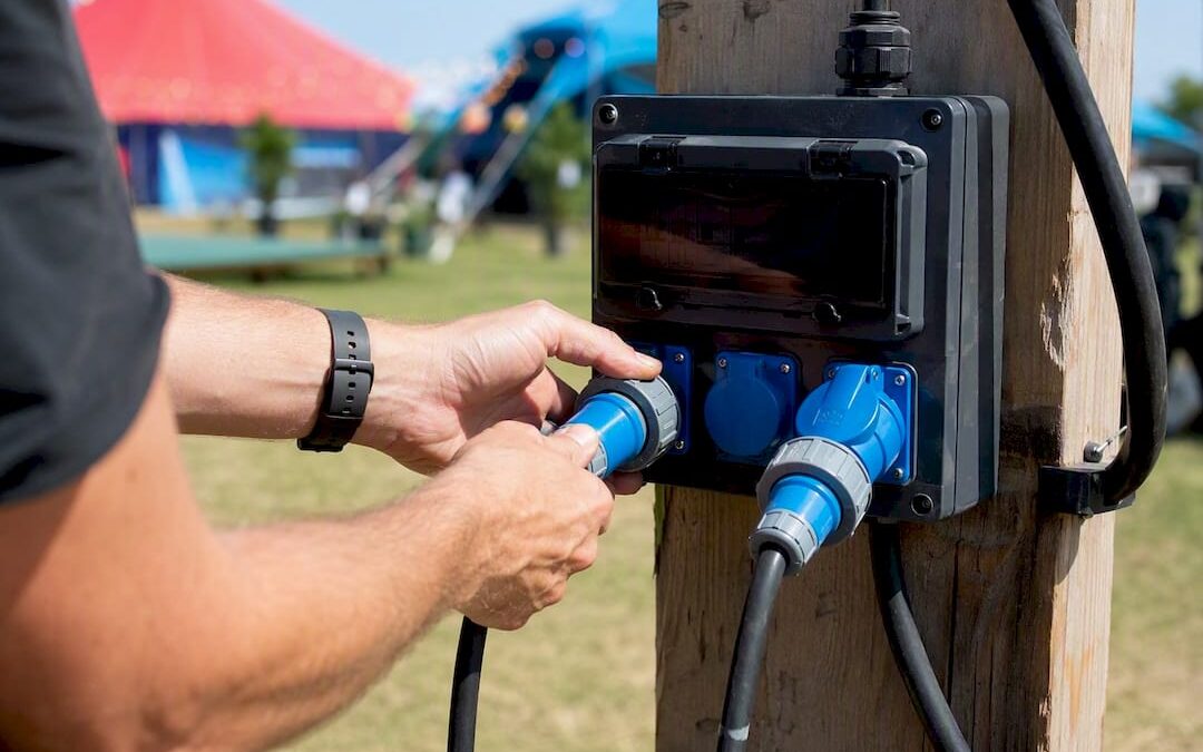 Technician connecting outdoor lighting cables to distribution board