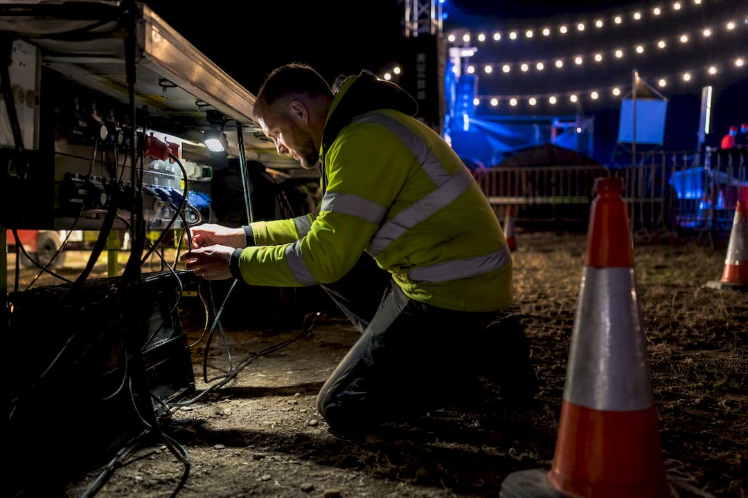 Technician inspecting power distribution wiring at night